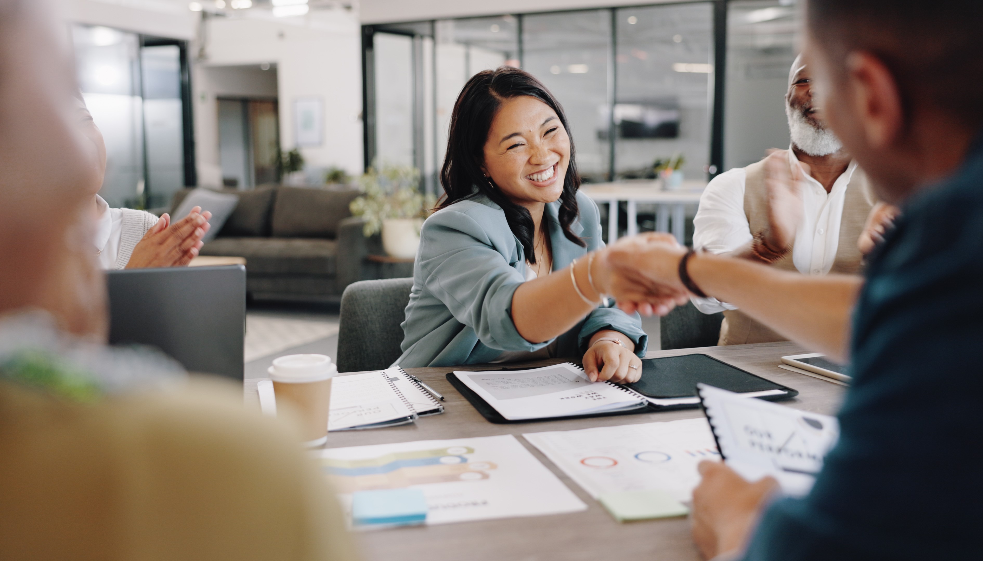 Person smiling and shaking hands with another person